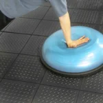 A blue Bosu ball on black interlocking floor mats