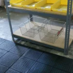 Black diamond-plate floor mats in a warehouse setting