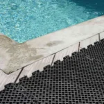 Black non-slip drainage mats installed by a pool