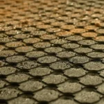 Close-up of wet black rubber matting with drainage holes
