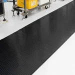 Long black rubber runner mat in a warehouse setting