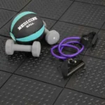 Medicine ball and dumbbells on black gym flooring