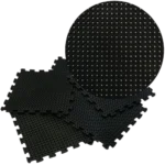 Stack of interlocking black drainage floor tiles